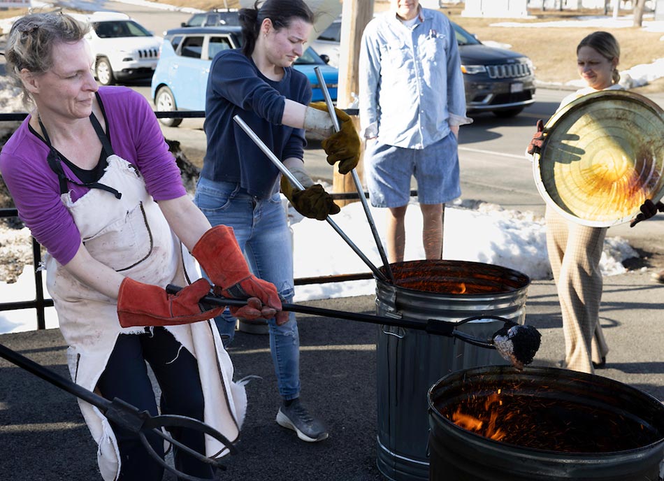 Carefully removing hot pieces from raku firing